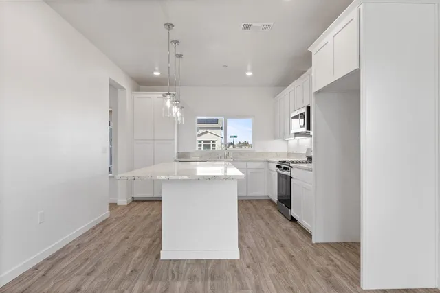 a kitchen with white cabinets and stainless steel appliances