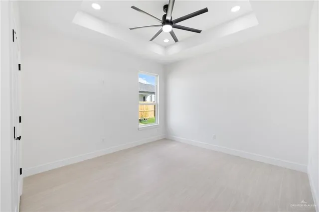 an empty room with a window and ceiling fan
