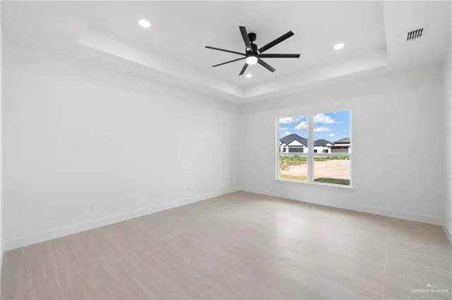 an empty room with windows and fan