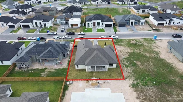 an aerial view of multiple houses with a yard