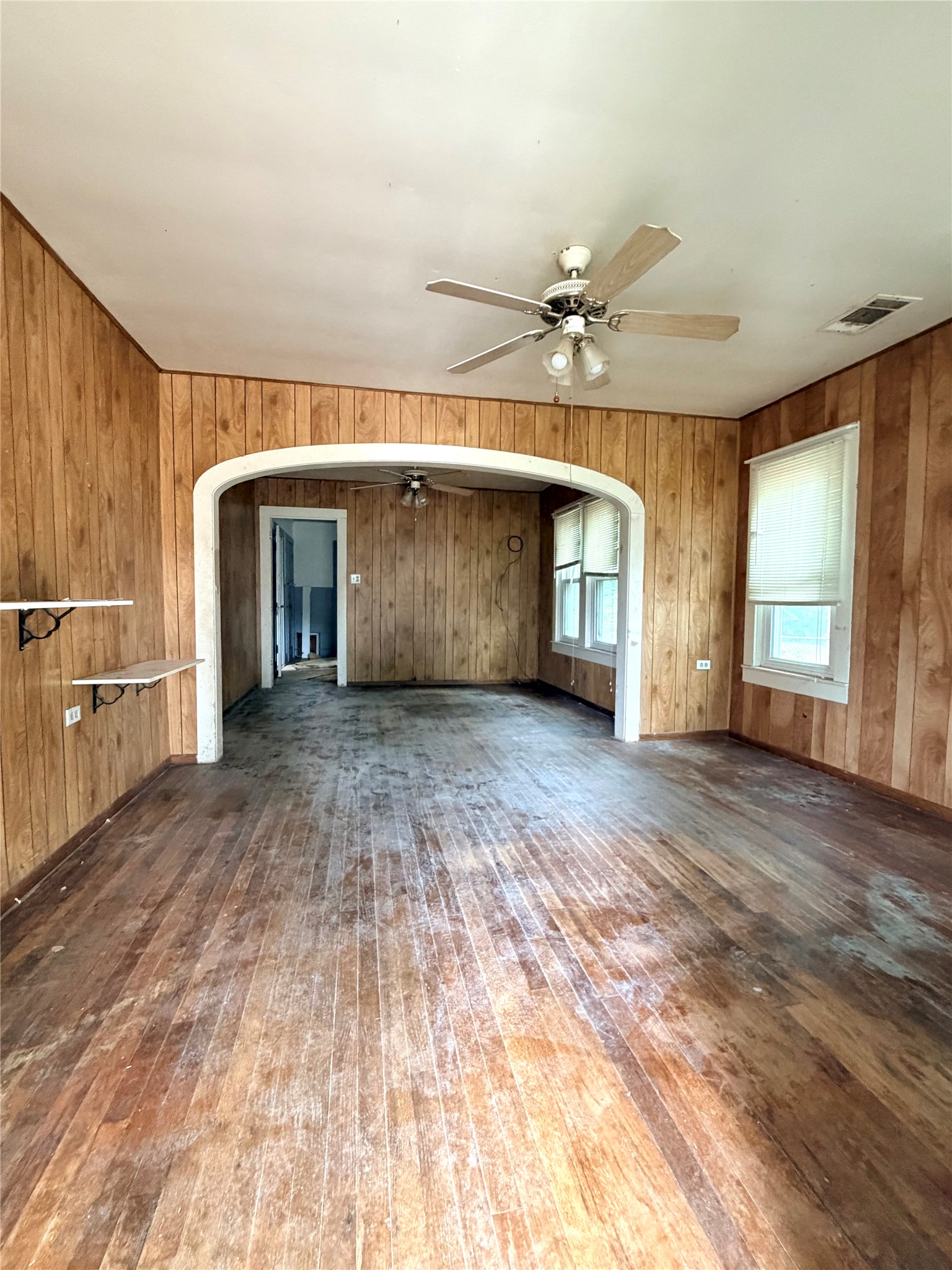 702 East 18th Street Cameron, TX 76520 - Photo 6 of 14 Hardwood floors and paneling create a cozy atmosphere in this adaptable living area.