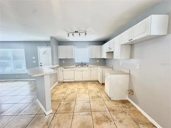 a large kitchen with stainless steel appliances granite countertop a sink and cabinets