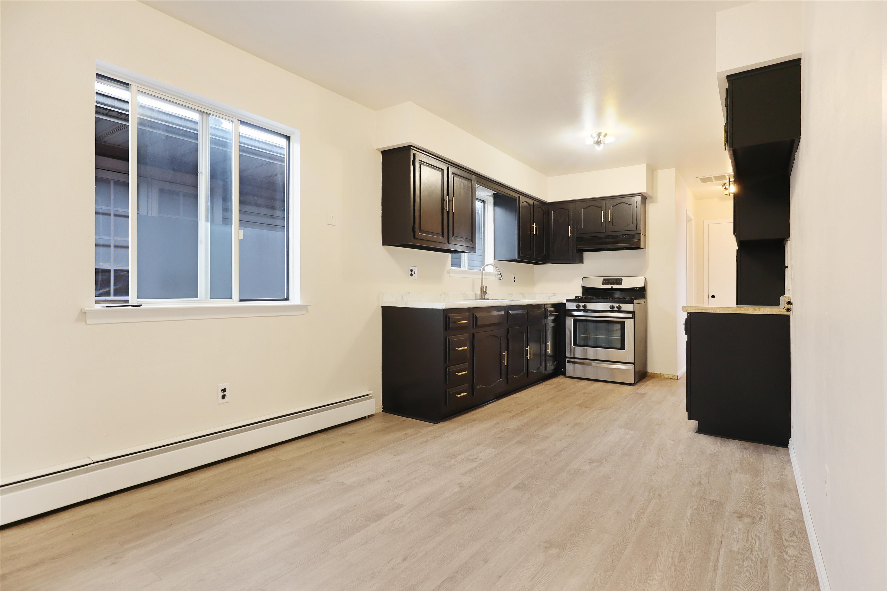 711 Bergen Street, Unit 2 Harrison, NJ 07029 - Photo 7 of 13 a large kitchen with stainless steel appliances granite countertop a stove and a sink