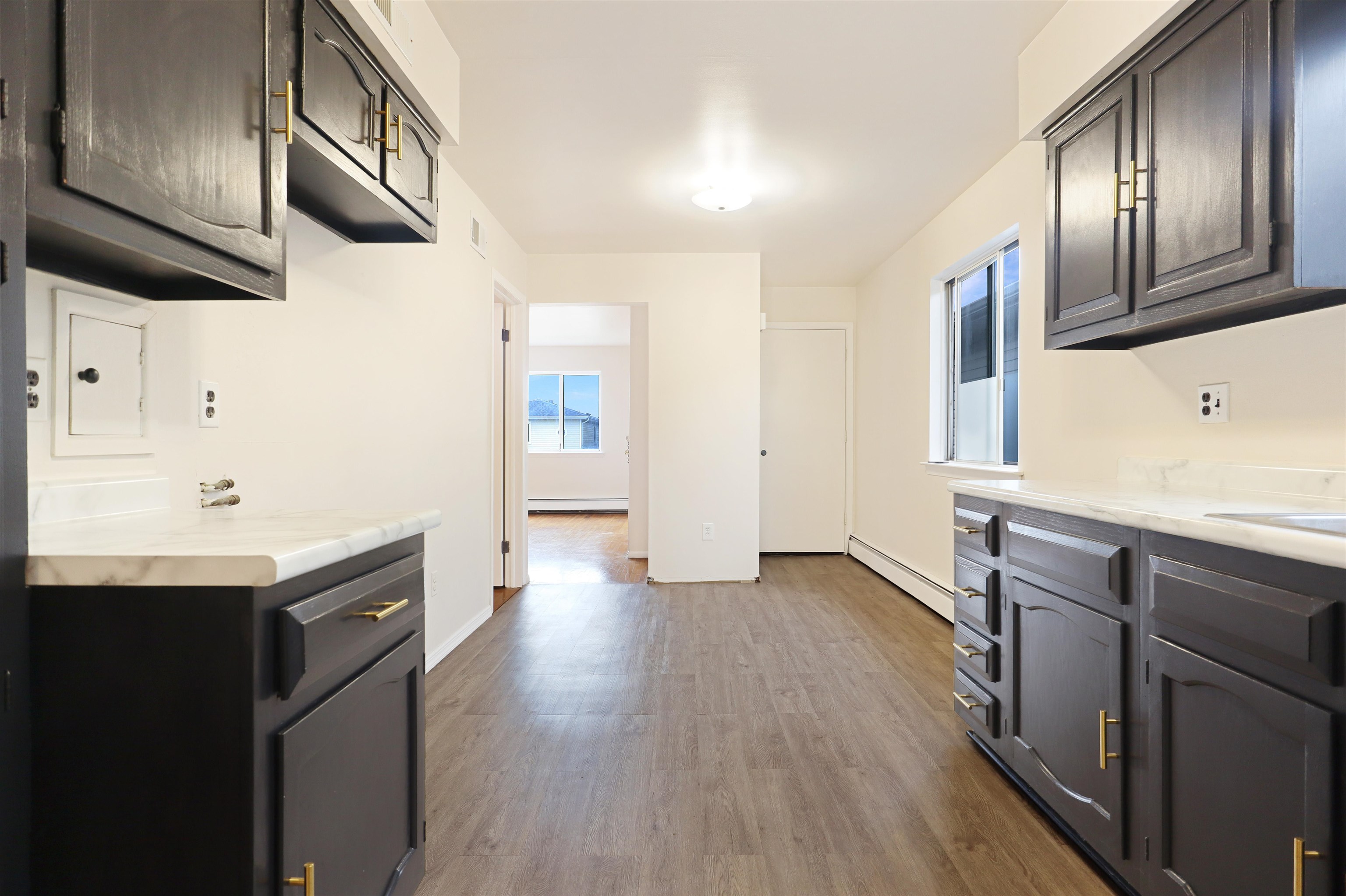 711 Bergen Street, Unit 2 Harrison, NJ 07029 - Photo 9 of 13 a kitchen with stainless steel appliances granite countertop a sink a stove and a wooden floors
