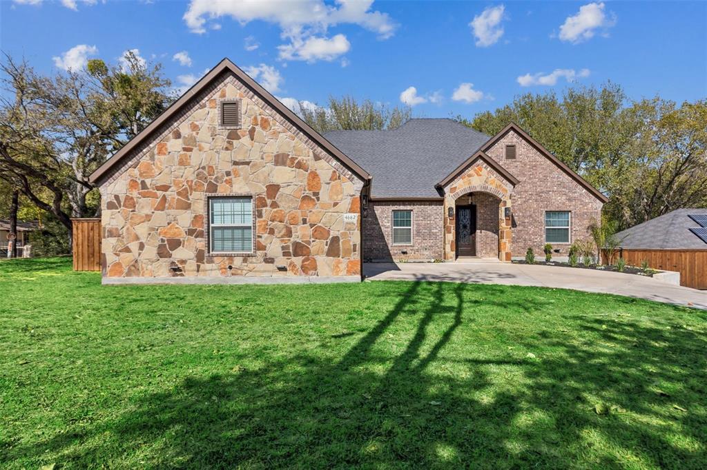 4662 Barbara Road River Oaks, TX 76114 - Photo 2 of 14 Stone and brick exterior with a dark shingle roof, arched entry, and a paved driveway
