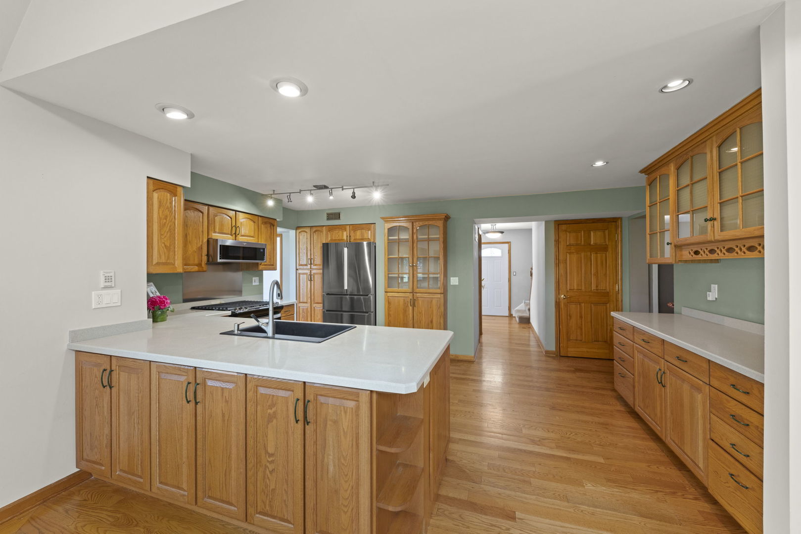 2114 Countryside Circle Naperville, IL 60565 - Photo 10 of 29 a kitchen with stainless steel appliances granite countertop a stove a sink a refrigerator and white cabinets with wooden floor