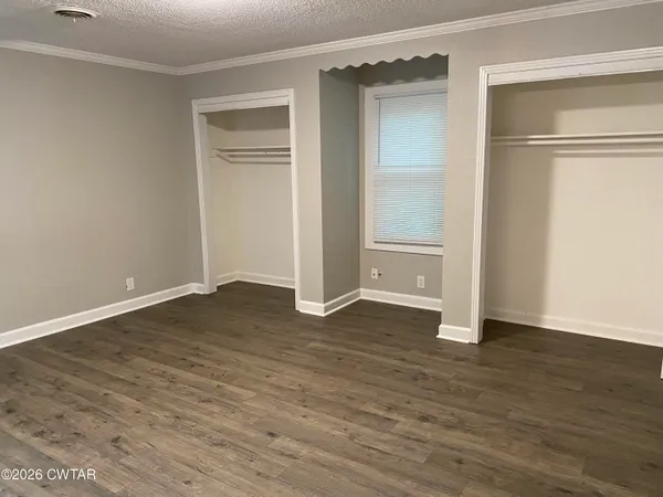 a view of empty room with wooden floor and closet