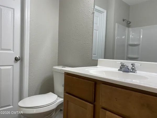 a bathroom with a granite countertop sink toilet and mirror