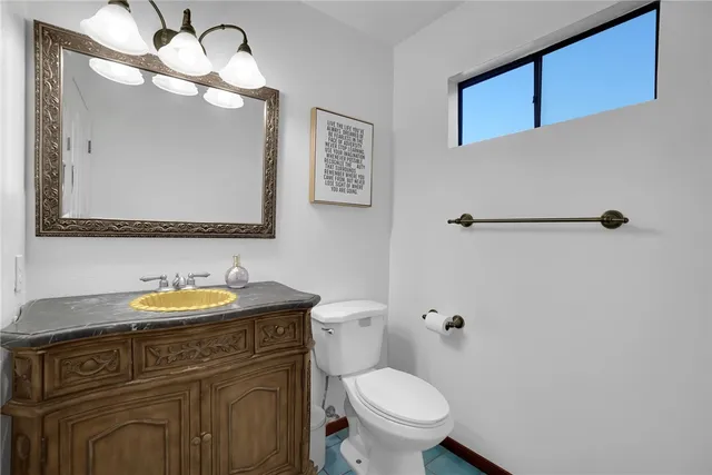 a bathroom with a toilet a sink and mirror