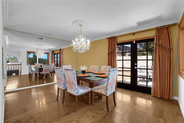 a view of a dining room with furniture a chandelier and wooden floor