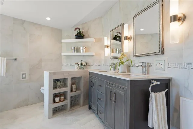 a bathroom with a sink a toilet and shower