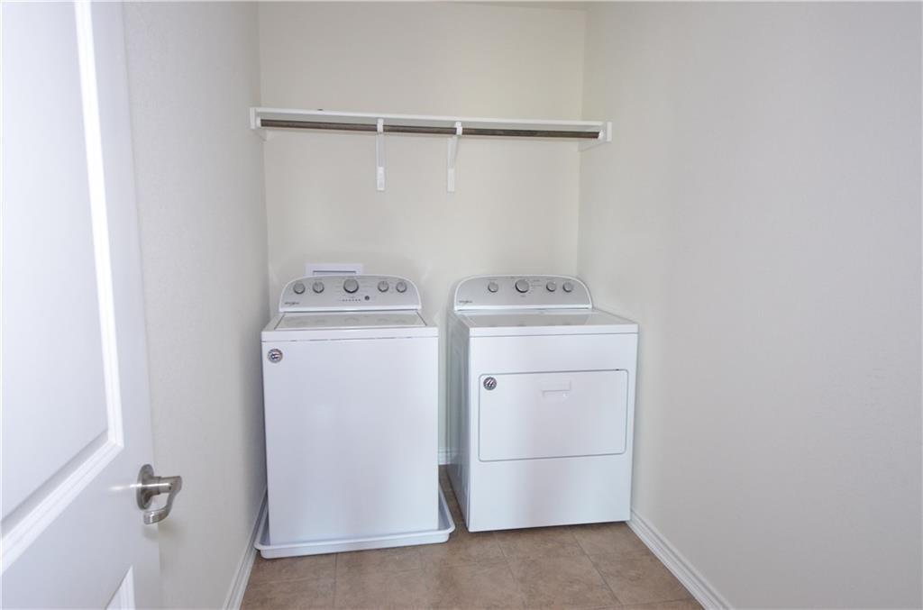 14403 McCoy Loop Austin, TX 78717 - Photo 23 of 29 A dedicated laundry space with a practical hanging rod and durable tile flooring.
