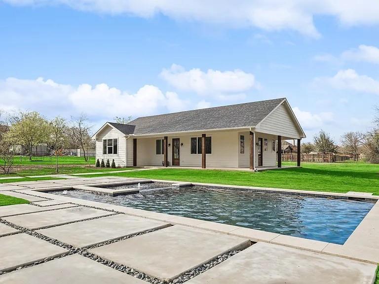 a front view of a house with a yard and trees