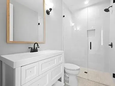 a bathroom with a sink a toilet and shower