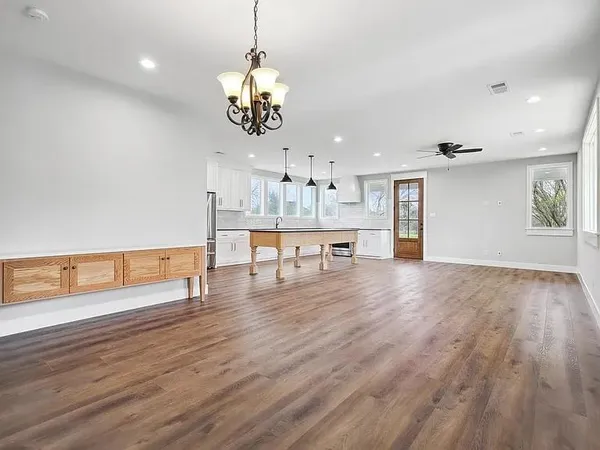 a view of a room with wooden floor fireplace and windows