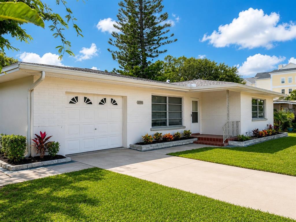 1559 Barry Road Clearwater, FL 33756 - Photo 1 of 20 a front view of a house with a yard and garage