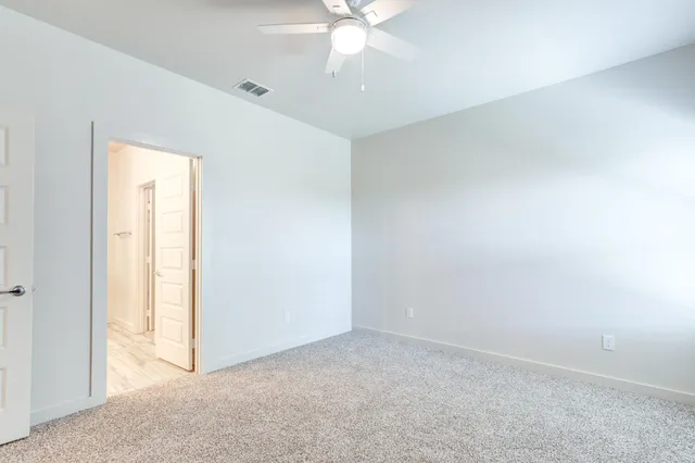 an empty room with a ceiling fan and a window