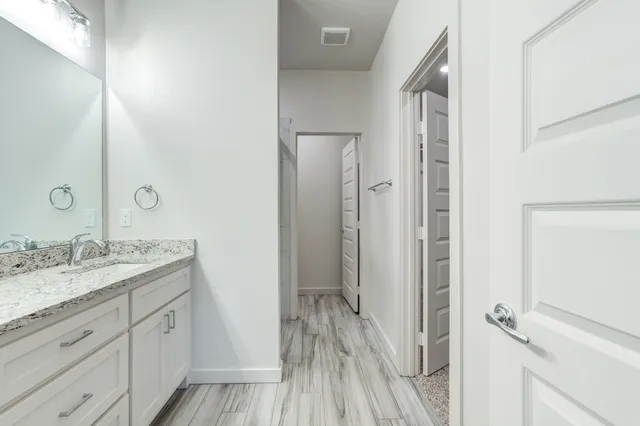 a bathroom with a granite countertop sink toilet and shower