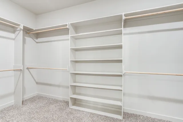 a view of walk in closet with empty racks
