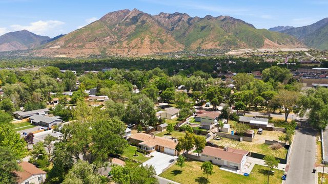 6889 South Village Road Salt Lake City, UT 84121 - Photo 40 of 44 Expansive mountain backdrop overlooking a residential neighborhood with mature trees