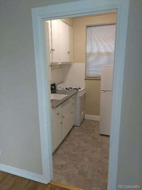 2966 West Denver Place Denver, CO 80211 - Photo 5 of 6 a kitchen with a sink a stove and cabinets