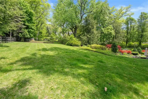 a view of a brick house with a yard and plants