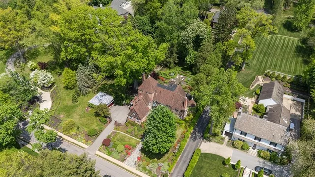 an aerial view of residential house with outdoor space and trees all around