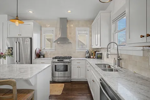 a kitchen with stainless steel appliances granite countertop a sink stove and refrigerator