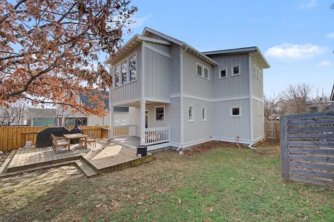 a view of a house with a large tree and wooden fence