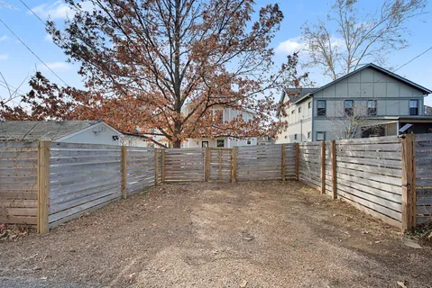 a backyard of a house with barbeque oven table and chairs