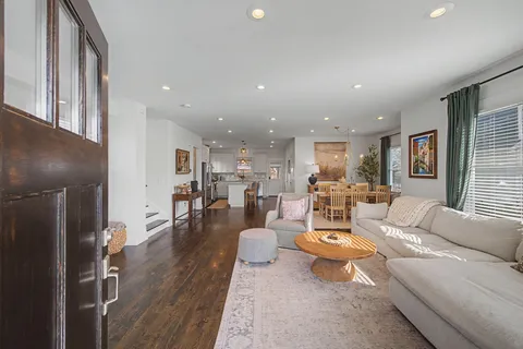 a living room with furniture and a wooden floor