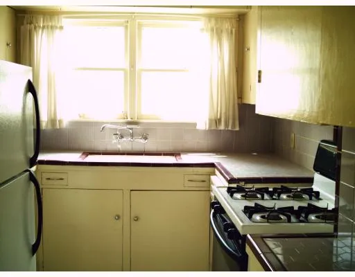 a kitchen with a stove and a white cabinet