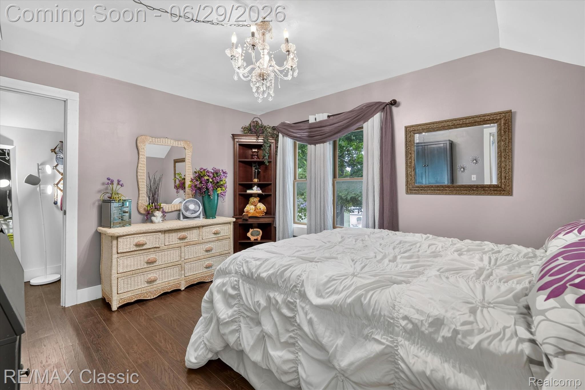 352 Meribah Road Highland, MI 48356 - Photo 24 of 39 Hardwood-style flooring throughout this room, featuring a vaulted ceiling and a chandelier with crystal accents