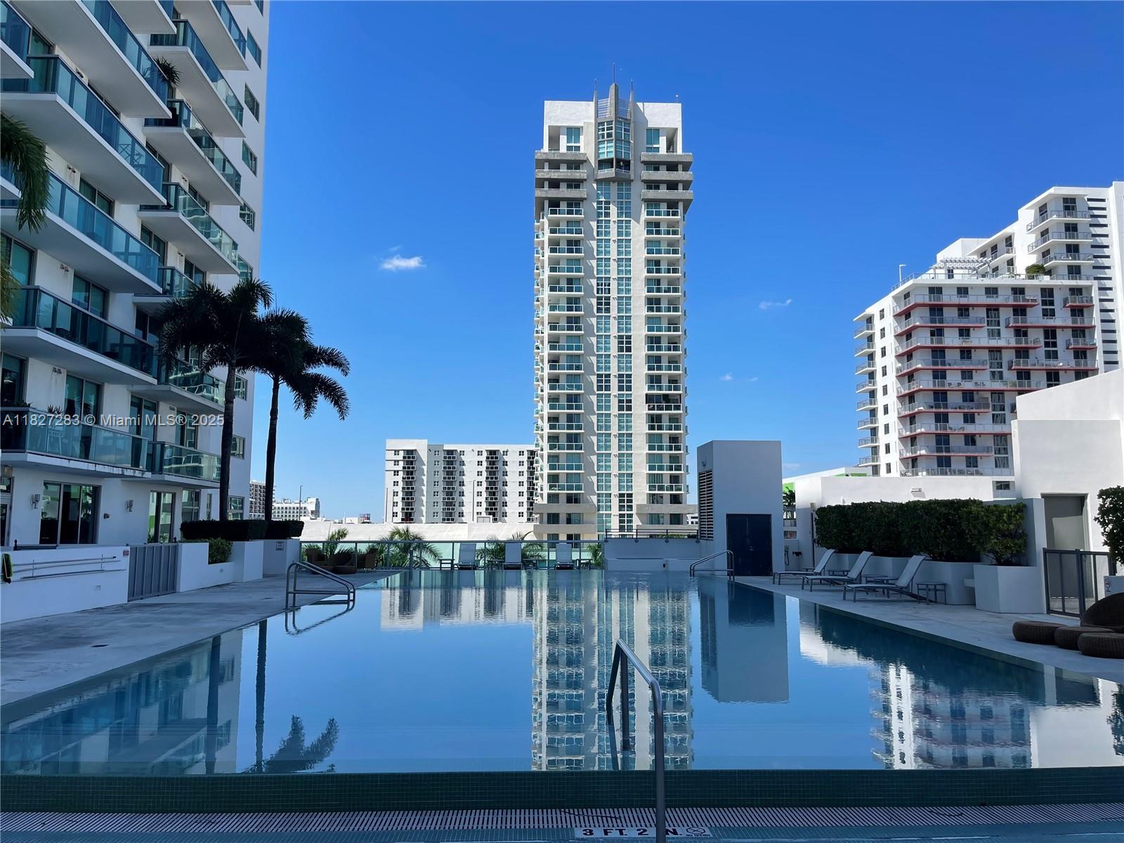 Edgewater Miami, FL 33137 - Photo 18 of 21 a living room with furniture a flat screen tv and a fireplace