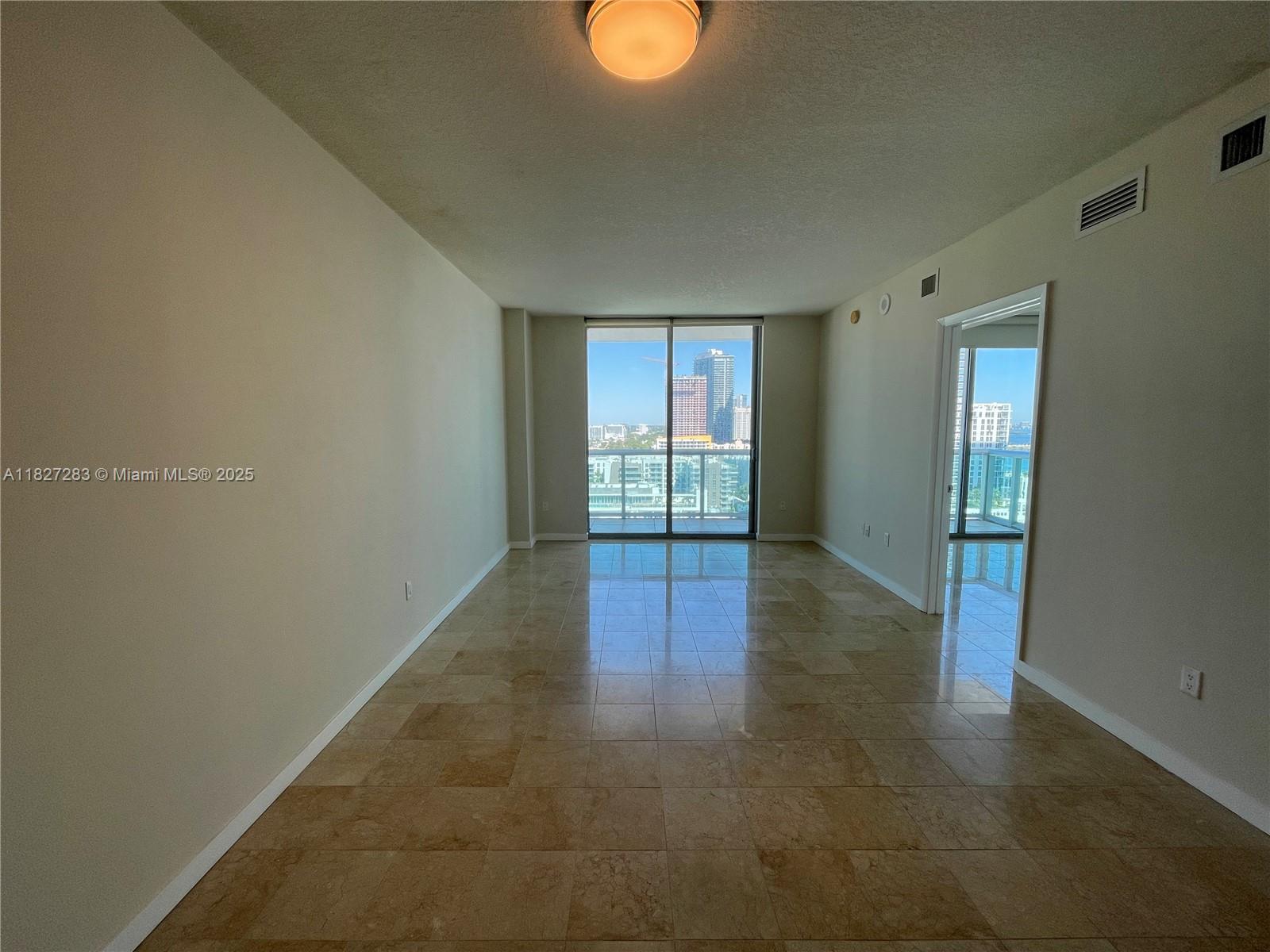 Edgewater Miami, FL 33137 - Photo 10 of 21 an empty room with wooden floor and windows