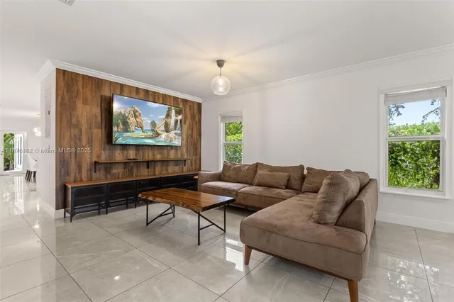 a living room with furniture a chandelier and a window