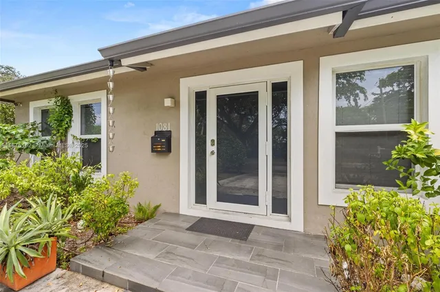 an aerial view of residential houses with outdoor space and trees