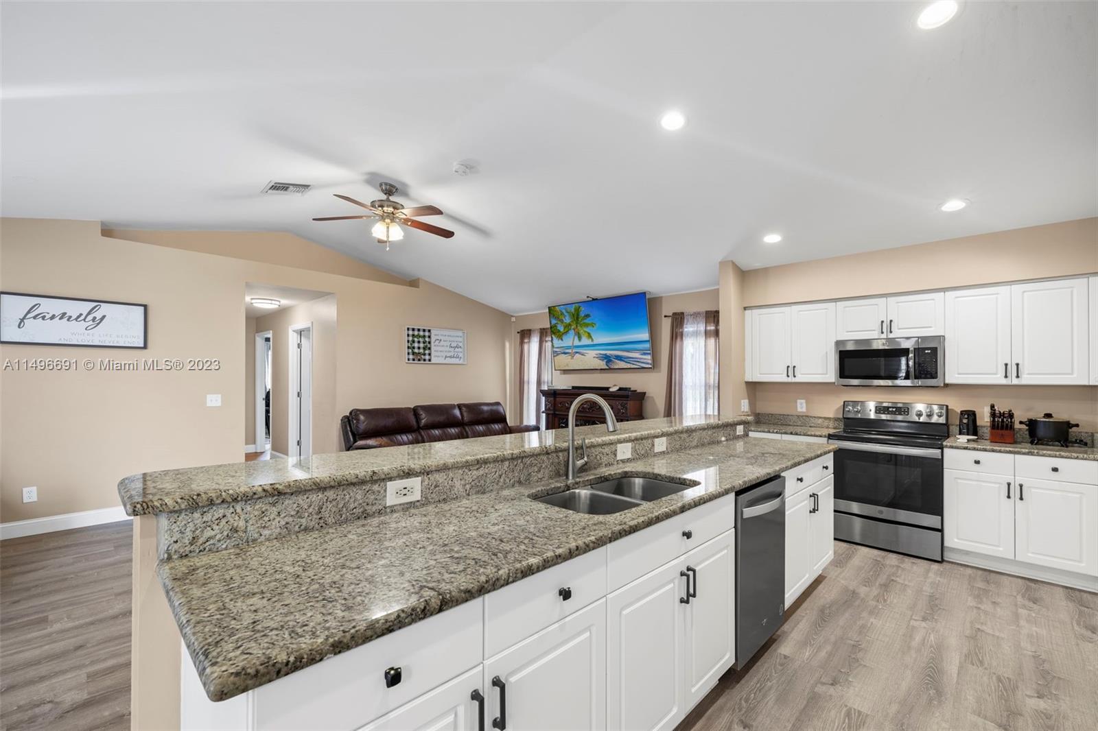 775 Arundel Circle Fort Myers, FL 33913 - Photo 12 of 26 a kitchen with stainless steel appliances granite countertop a sink stove and refrigerator