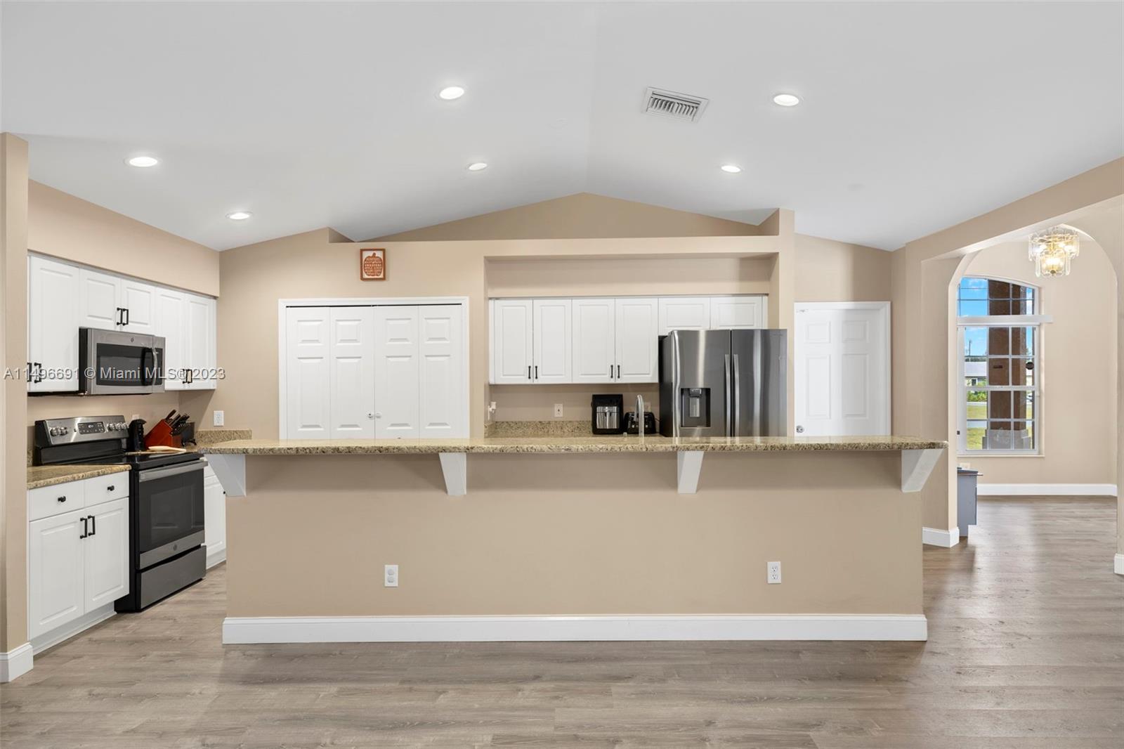 775 Arundel Circle Fort Myers, FL 33913 - Photo 10 of 26 a view of a kitchen with kitchen island a sink wooden floor and black appliances