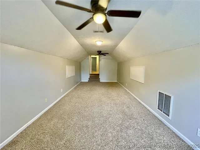 en empty room with windows and ceiling fan