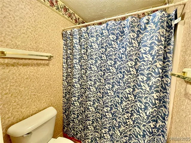 a white toilet sitting next to a shower curtain