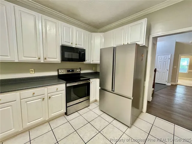 a kitchen with white cabinets and stainless steel appliances
