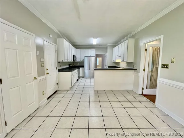 a large white kitchen with cabinets and a stove top oven