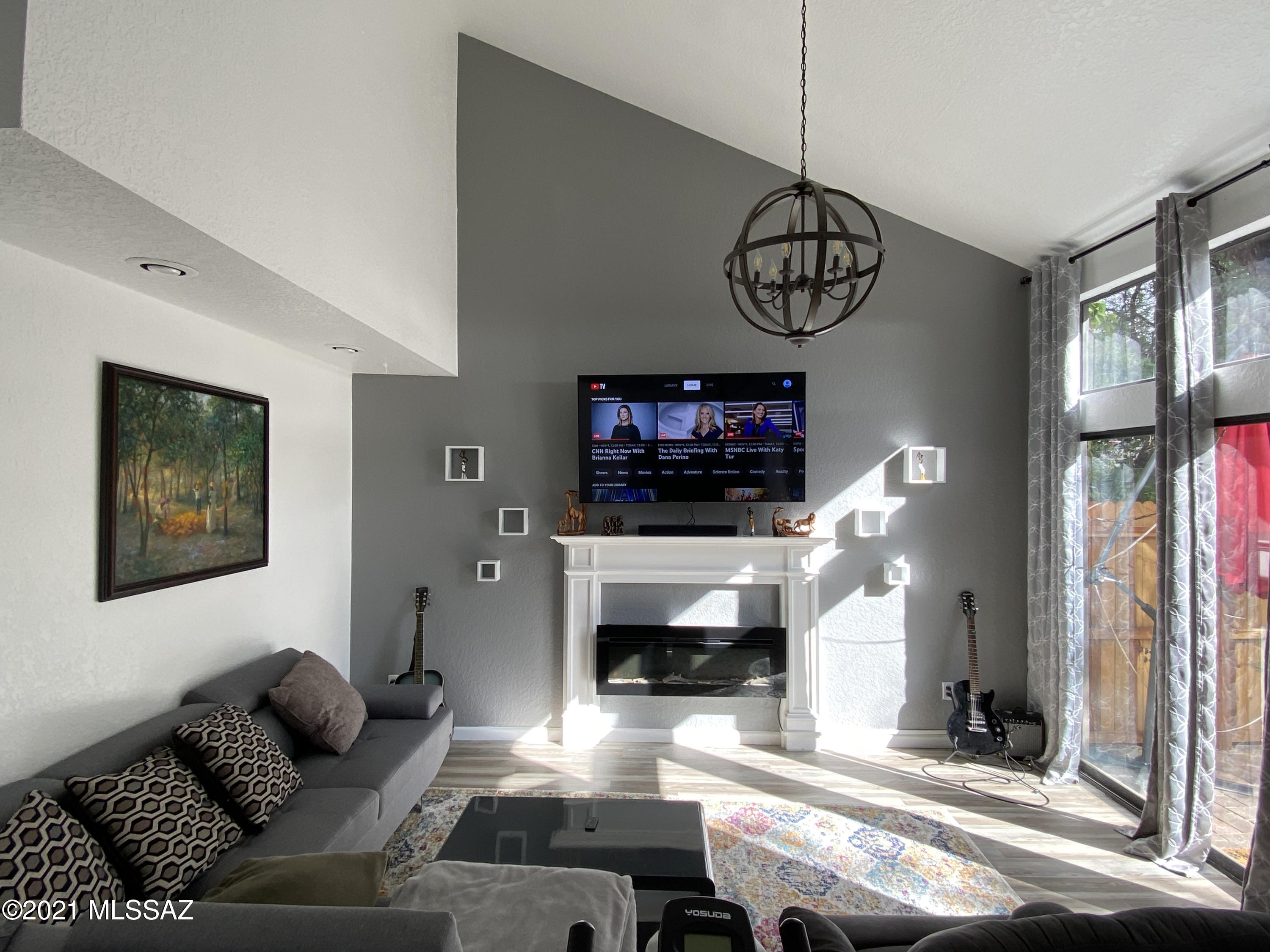 236 East Pastime Road Tucson, AZ 85705 - Photo 4 of 20 a living room with furniture a flat screen tv and a fireplace