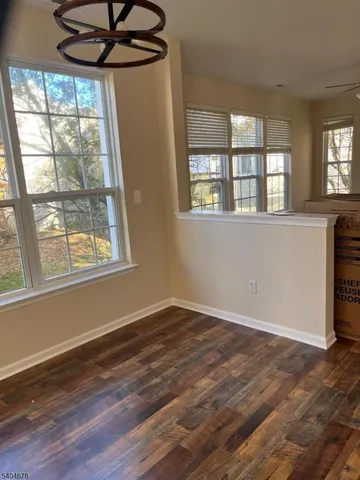 a view of empty room with window and wooden floor