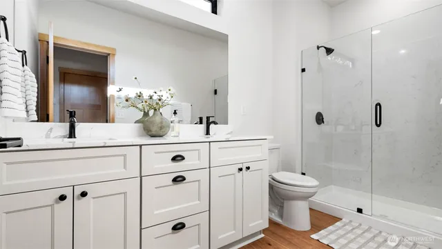 a bathroom with a double vanity sink toilet and shower