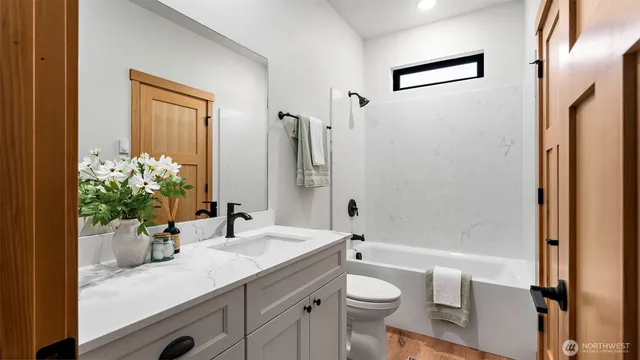 a bathroom with a granite countertop sink a toilet and shower