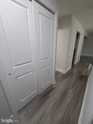 a view of a storage and utility room with wooden floor