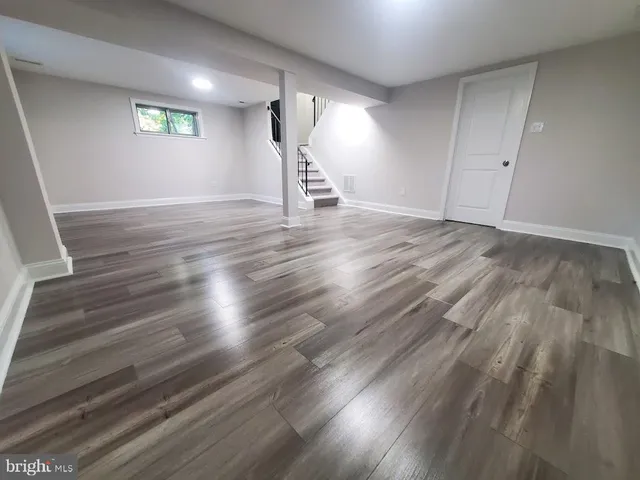 an empty room with wooden floor and a ceiling fan