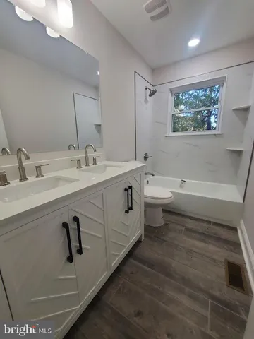 a bathroom with a double vanity sink toilet and a mirror